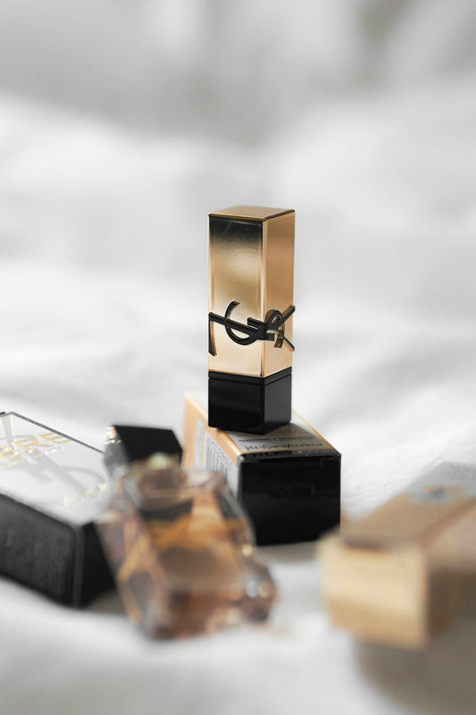 A bottle of perfume sitting on top of a bed